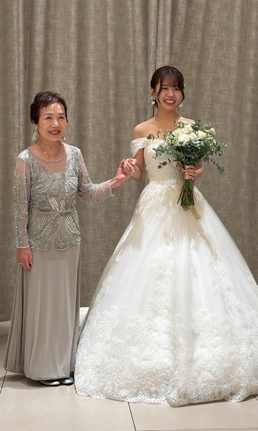 結婚式で手をつなぎ笑顔を見せる花嫁と祖母のツーショット