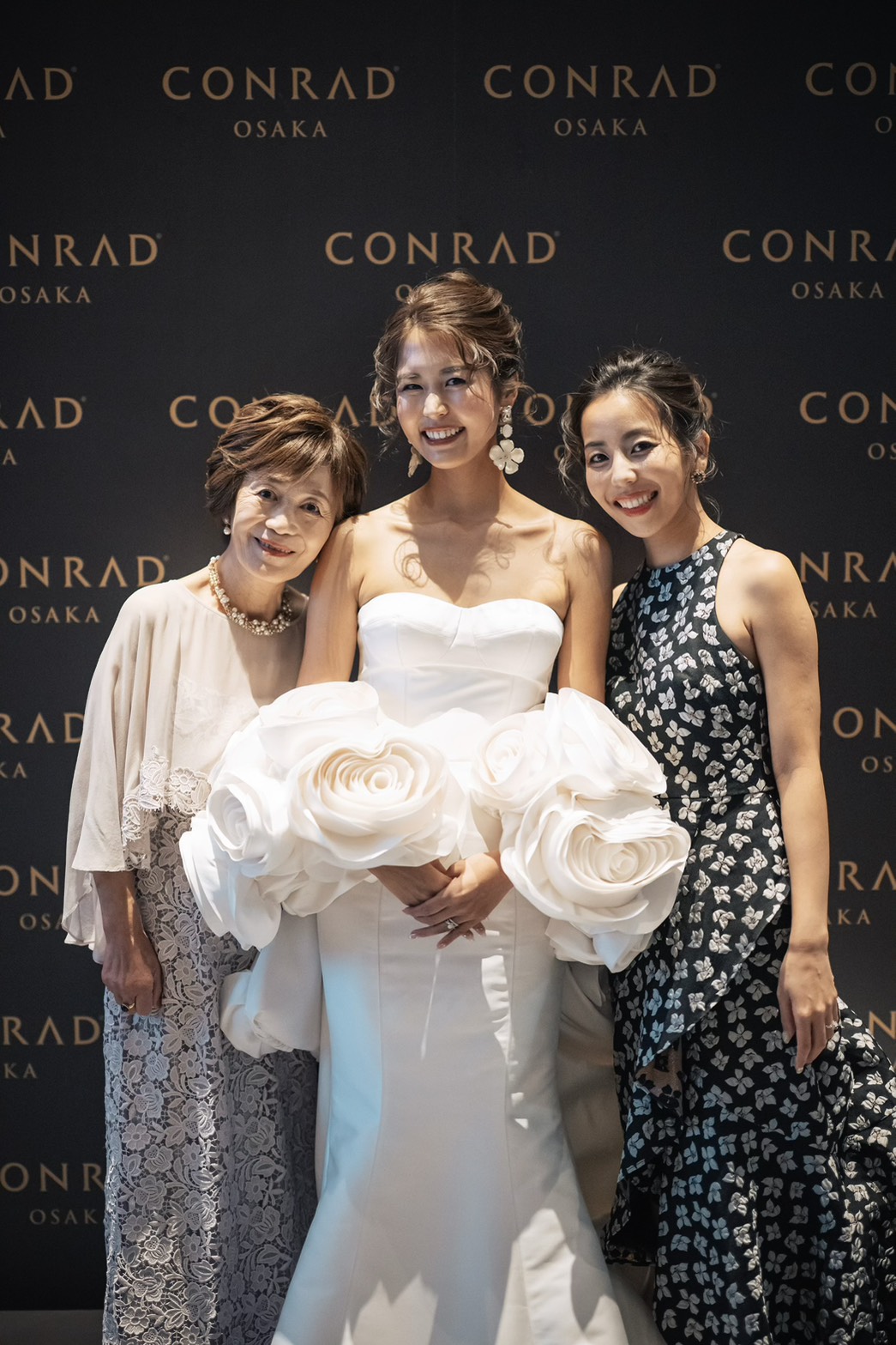 花嫁と新婦母、新婦姉のスリーショット。グレーラベンダーのシフォンケープマザードレスを着た新婦母とウェディングドレスの花嫁