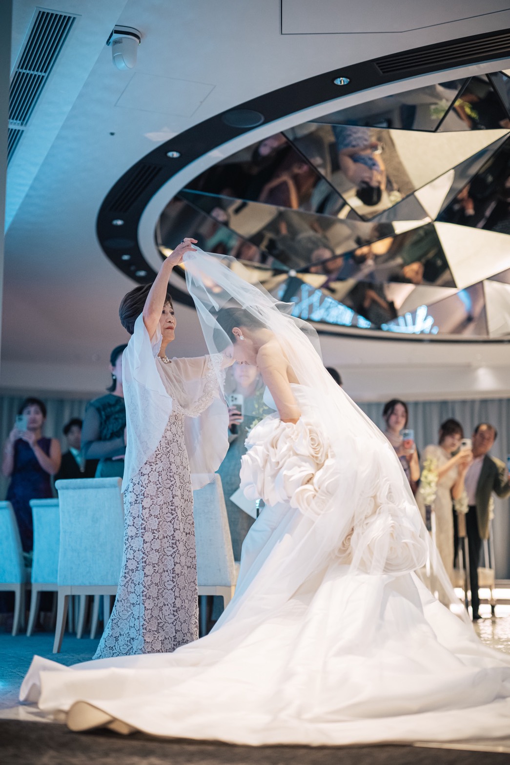 ベールダウンで花嫁のベールを持ち上げる新婦母。グレーラベンダーのケープ付きマザードレス